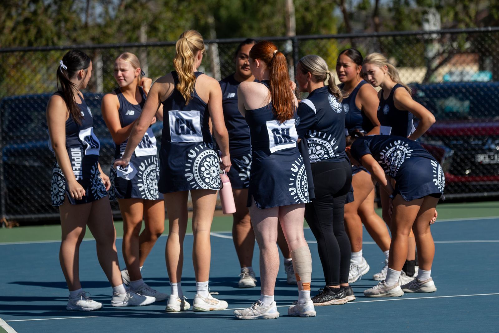Hoppers Rep squad and coaches gathered courtside in their indigenous dresses